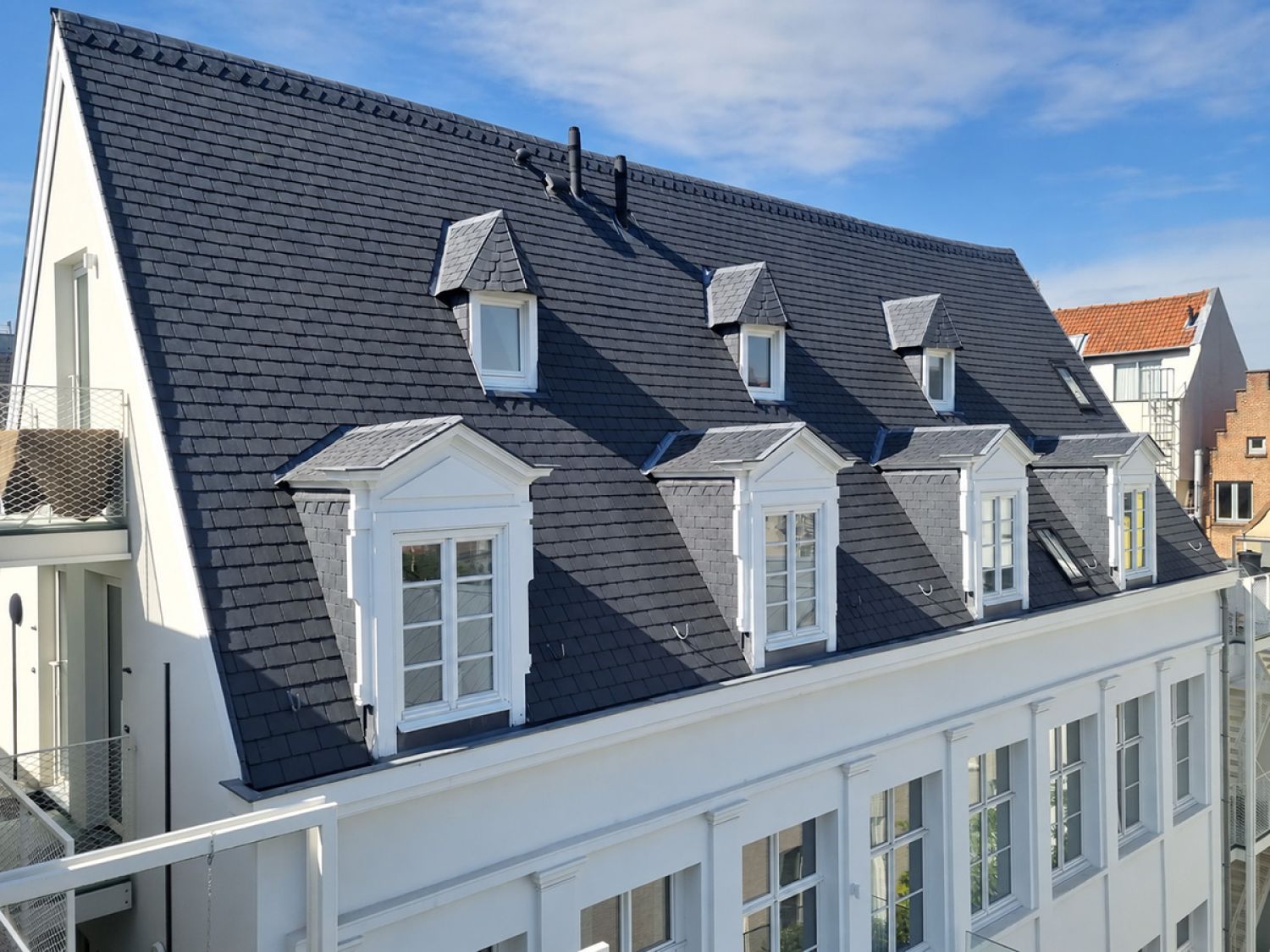Detail van gerenoveerd dak met leien en zink